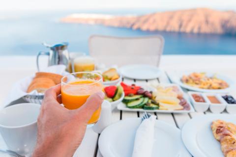 Persona comiendo comida mediterránea frente al mar