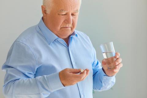 Anciano tomando aspirinas para prevenir un ictus
