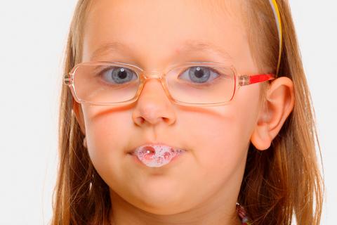 Una niña haciendo pompas con la saliva