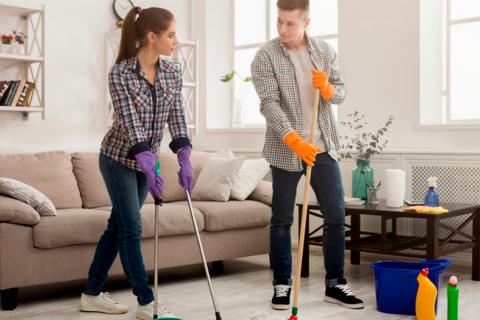 Una pareja joven realizando las tareas del hogar