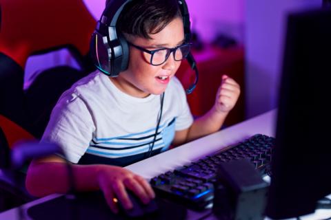 Niño jugando con el ordenador en su habitación