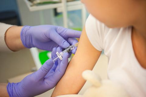 Sanitario pone una vacuna contra la difteria a un niño