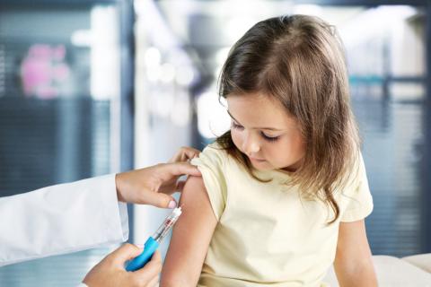Pediatra vacuna de la gripe a niña pequeña
