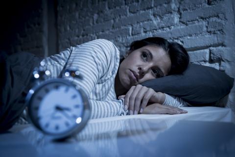 Mujer en la cama sin poder dormir por culpa del insomnio