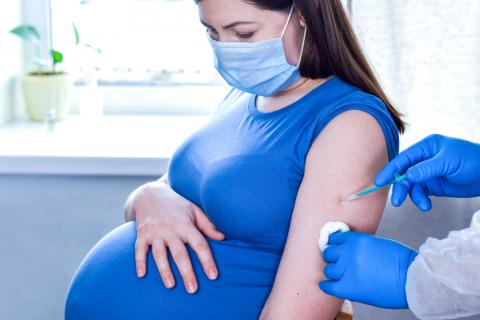 Mujer embarazada poniéndose la vacuna contra el COVID-19