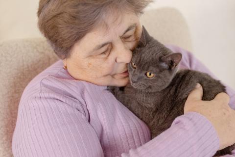 Mujer mayor abrazando a su gato