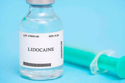 Un frasco con lidocaína junto a una jeringuilla para anestesiar