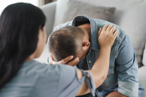 Persona joven con depresión siendo consolado por una psicóloga