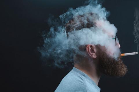 Persona fumando con la cabeza envuelta en humo