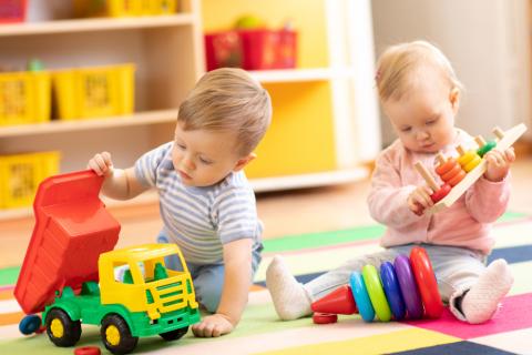 Niña y niño en edad preescolar juegan con juguetes educativos