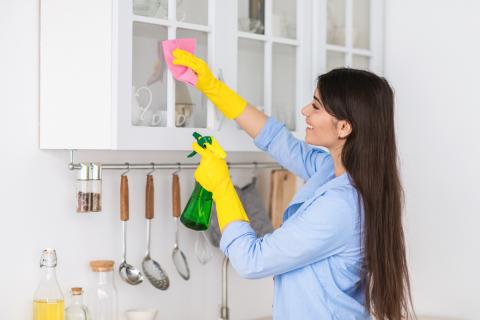 Mujer usando productos químicos de limpieza en casa