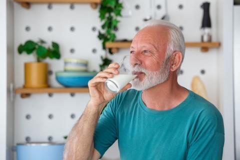 Hombre mayor bebe un baso de leche