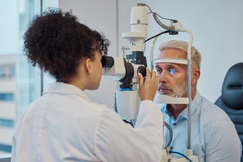 Doctora realizando un examen ocular a un hombre mayor