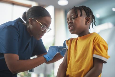 Enfermera poniendo una vacuna a un niño