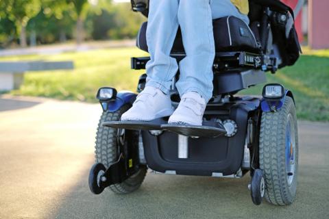 Mujer con ELA sentada en una silla de ruedas motorizada
