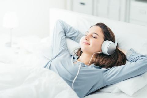 Chica joven escucha palabras relajantes mientras duerme