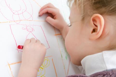 Niño dibujando con la mano izquierda