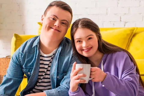 Dos niños con discapacidad intelectual sonríen a la cámara