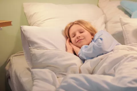 Niña pequeña acostada en la cama pronto