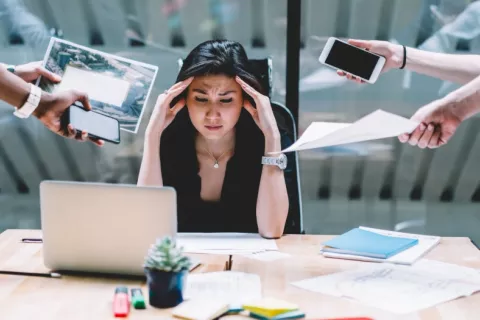 Las jornadas de trabajo prolongadas pueden afectar negativamente al cerebro Mujer en su puesto de trabajo agobiada por exceso de tareas que le asignan
