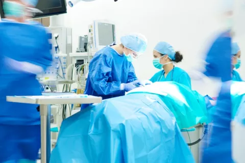 Cirujanos durante la práctica de una intervención quirúrgica Equipo de cirujanos se dispone a realizar una cirugía en un quirófano