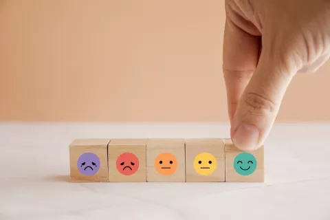 Piezas de madera con emojis de emociones de colores