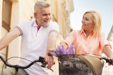 Pareja madura se desplazan en bicicleta por la ciudad Hombre y mujer de mediana edad montando en bicicleta