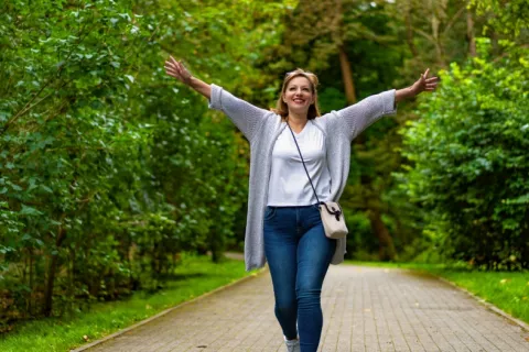 Mujer disfruta de su paseo por una senda en el parque