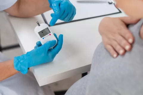 Embarazada en consulta médica para controlar su diabetes gestacional Doctora comprueba los niveles de azúcar en sangre de una embarazada