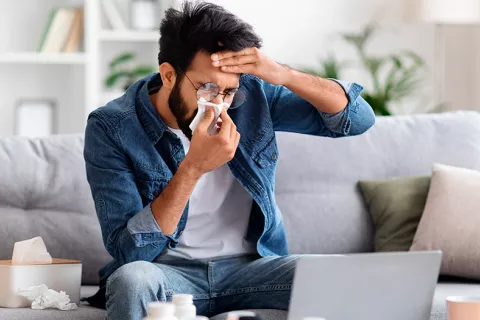 Hombre sonándose por alergia