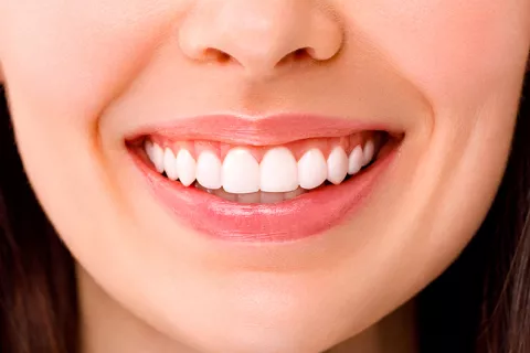 Detección de párkinson mediante la sonrisa Una mujer con una sonrisa con dientes blancos