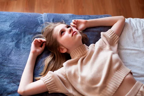 Adolescente afectada por tóxicos ambientales Muchacha triste por menstruación