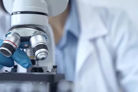 Científico usando microscopio en laboratorio
