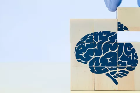 Concepto de terapia para solucionar efectos del alzhéimer en el cerebro Encajando la última pieza de un puzle de madera con un cerebro dibujado