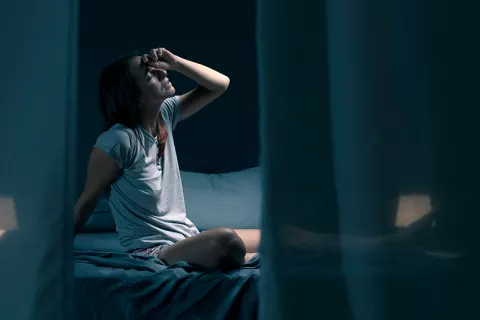 Mujer con sueño fragmentado se despierta en una habitación oscura