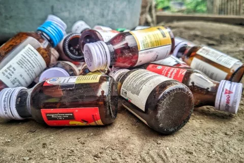Jarabes y medicamentos contaminados peligrosos para la salud Botes vacíos en el suelo de jarabes para la tos contaminados