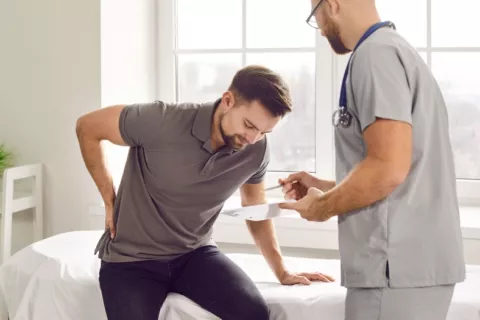 Hombre joven con lumbalgia en la consulta del doctor