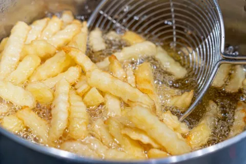 Patatas friéndose en aceite hirviendo