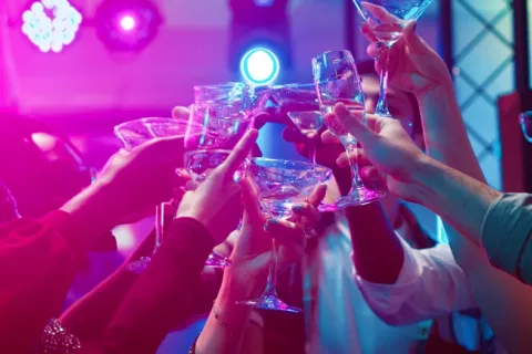 Amigos brindan con sus copas durante una fiesta en un local nocturno