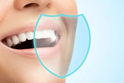 Dentadura sana de una mujer con dibujo de escudo protector sobre ella