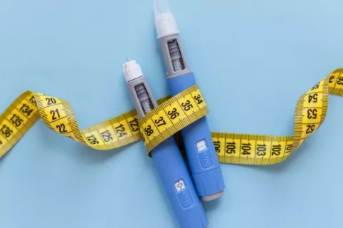 Medicamentos para perder peso inyectables rodeados por cinta métrica Dos inyecciones subcutáneas de fármacos antiobesidad rodeadas por una cinta métrica