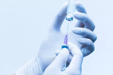 Fármaco inyectable para prevenir la infección por VIH Manos enguantadas de sanitario sujetan vial y jeringuilla