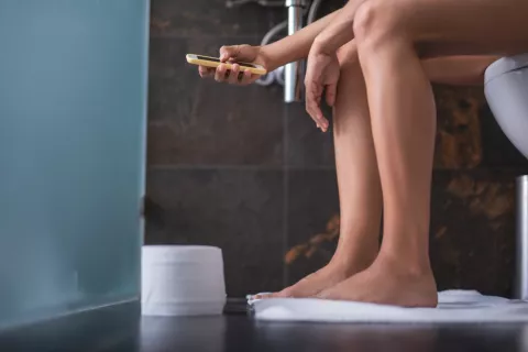 Uso del teléfono inteligente en la taza del baño