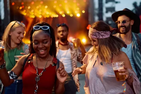 Jóvenes beben cerveza en un concierto al aire libre