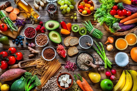 Gran variedad de alimentos coloridos dispuestos sobre una mesa de madera