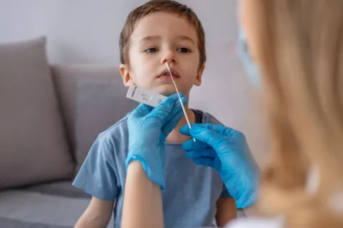 Mujer realiza prueba COVID a un niño pequeño