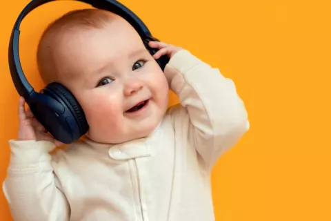 Bebé muy sonriente con unos auriculares