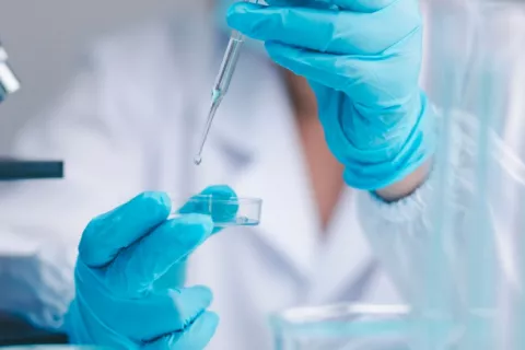 Investigador realiza un experimento para desarrollar una vacuna Científico realiza pruebas con un líquido en su laboratorio