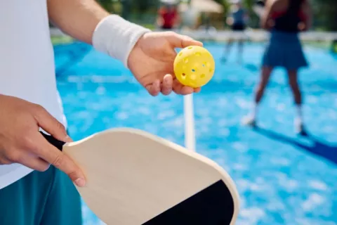 Cuatro personas juegan al pickleball Jugador de pickleball a punto de lanzar la pelota