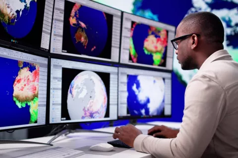 Meteorólogo analiza las consecuencias del cambio climático Meteorólogo frente a pantallas que muestran diferentes zonas del mundo